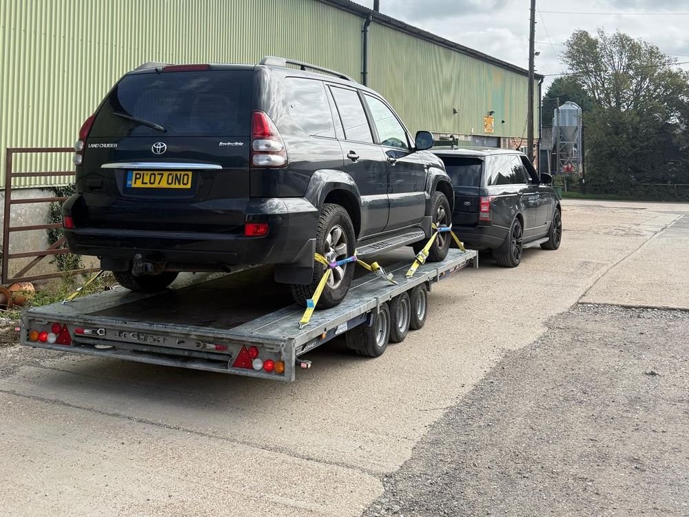 Toyota Land Cruiser strapped onto a trailer at a farm yard